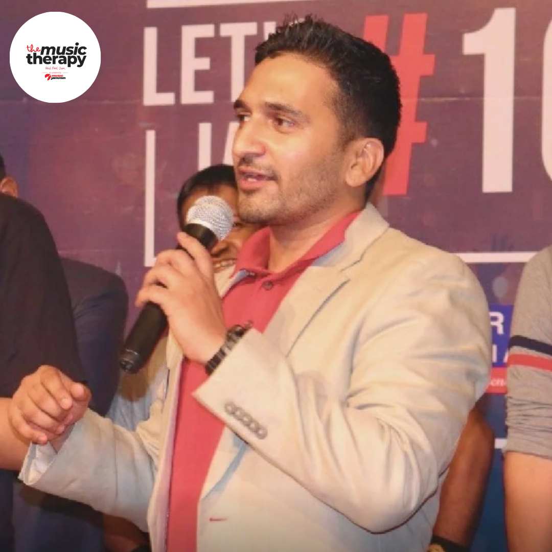 Host speaking on mic at a Music Jammin event backdrop